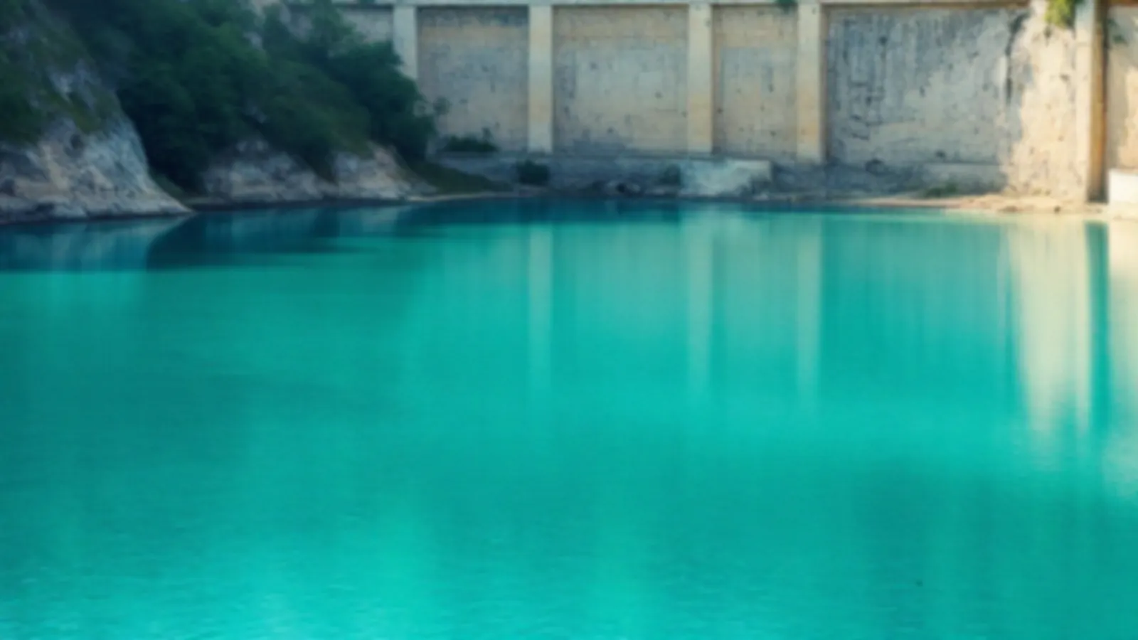 A turquoise quarry lake below pale stone walls and green trees in morning light, the NoteQuarry view of emergency cash loans online, $100 – $5,000